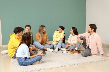 Grup terapisinde halıda konuşan gençler