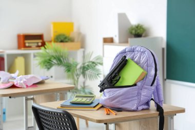 Sırt çantasında silah ve kitap var. Okul çekim konsepti