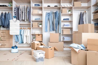 Giysileri, buharlı tenceresi ve kutuları olan gardırop.