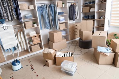 Giysileri, buharlı tenceresi ve kutuları olan gardırop.