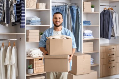 Soyunma odasında dolapları olan genç bir adam.