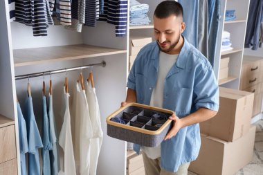 Kıyafet organizatörü olan genç bir adam.