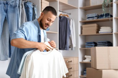 Soyunma odasında dolapları olan genç bir adam.