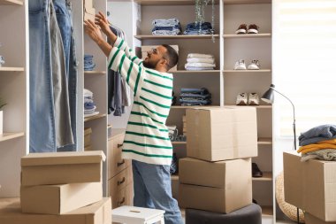 Soyunma odasında dolabında kutuları olan genç bir adam.