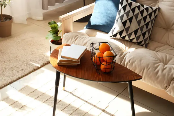 Oturma odasında kitap ve portakallı modern kahve masası, yakın plan.