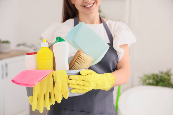 Уборщица с чистящими средствами в ванной, крупным планом