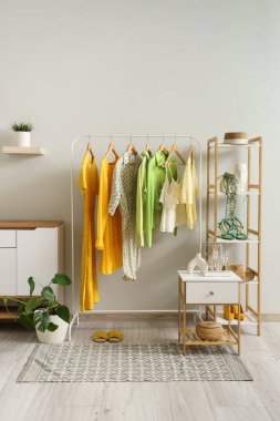 Giysi askısı, raf ünitesi ve masası olan soyunma odasının içinde.