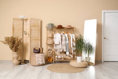 Giysi askısı, ayna ve katlama perdesi olan soyunma odasının içinde.