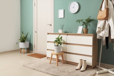 Koridorun içinde duvar saati, tuvalet ve elbise askısı var.