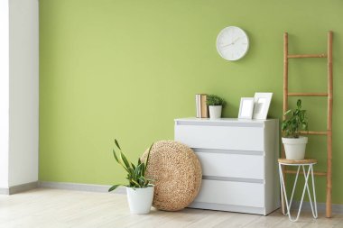 Oturma odasının içinde duvar saati, tuvalet ve merdiven var.