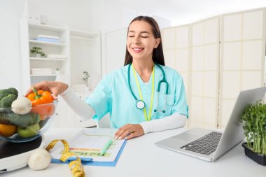 Ofisinde sebzeli kadın beslenme uzmanı.