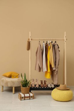 Bej duvarın yanında kadın giysileriyle dizilin.