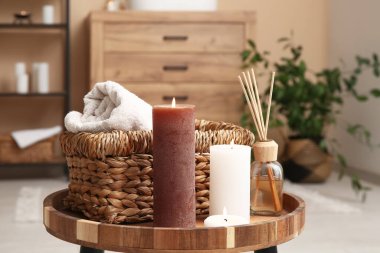 Banyodaki sepet ve havlularla mum yakmak, yakın plan.