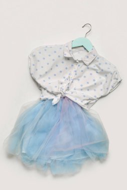 Gri arka planda şık çocuk kıyafetleri olan bir askı.