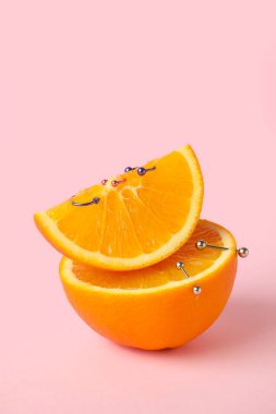 Pembe arka planı delinmiş portakal meyveleri.