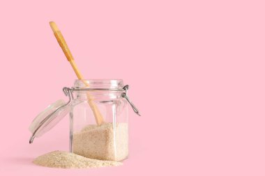 Pembe arka planda psyllium kabuklu kavanoz.