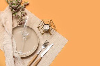 Çingene çiçekleri ve turuncu arka planda yanan mumlarla dolu güzel bir masa.