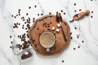 Beyaz arka planda şekerli ve fasulyeli bir bardak sıcak kahve.