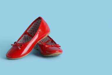 Mavi arka planda şirin bir kız ayakkabısı.