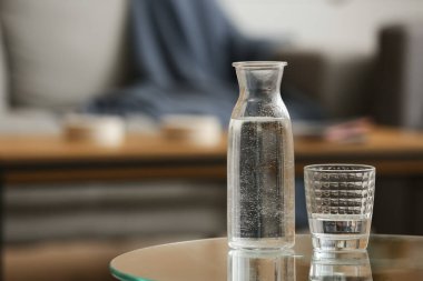 Odadaki masada bardak ve bir şişe su.