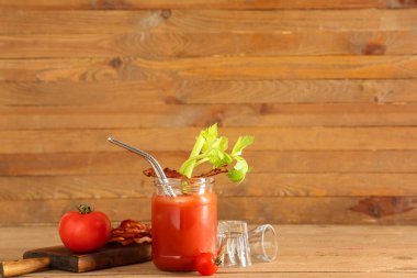 Mason kavanozu içinde domuz pastırması ve kereviz olan Bloody Mary kokteyli.