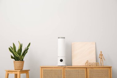 Oda odasındaki ışık duvarının yanındaki çekmecelerde boya ve dekor içeren hava nemlendirici.