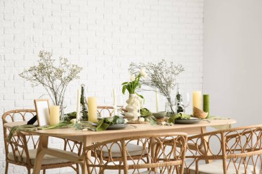 Hafif yemek odasında güzel çiçekler ve mumlar olan zarif bir masa.