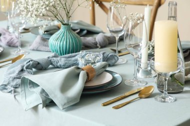 Altın çatal bıçak takımı, güzel çiçekler ve restoranda mumlar, yakın plan.