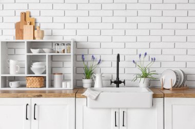 Havalı lavabo, güzel Muscari çiçekleri ve mutfak gereçleri olan raf ünitesi.