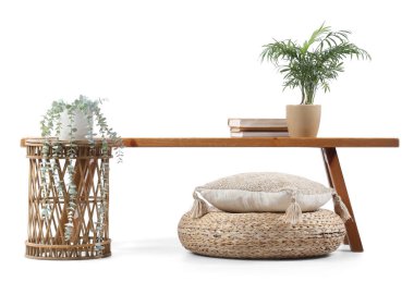 Kitapları, masası, bitkileri ve beyaz arka planı olan ahşap bir bank.