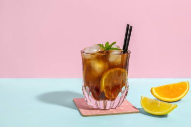 Bir bardak Long Island buzlu çay kokteyli. Nane ve narenciye arkaplanda mavi masada.