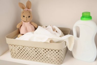 Oyuncak tavşan ve deterjan dolu çamaşır sepeti.