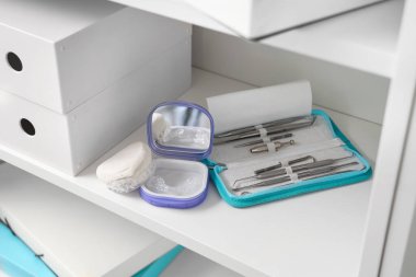 Diş hekiminin ofisindeki rafta oklüzyon bandı, çene modeli ve araçları bulunan kutu, yakın plan