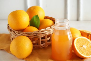 Bir şişe taze portakal suyu ve beyaz arka planda meyveler.