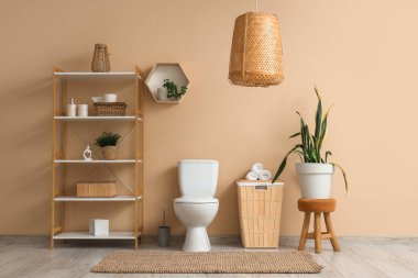 Tuvaletin içinde klozet, raf ünitesi ve sepet var.