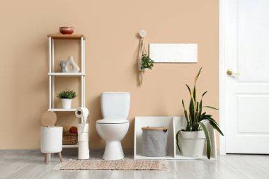 Tuvaletin içinde klozet, raf ünitesi ve bitkiler var.