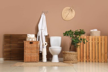 Tuvaletin içinde klozet, sepet ve bornoz var.