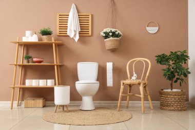 Tuvaletin içinde klozet, raf ünitesi ve sandalye var.