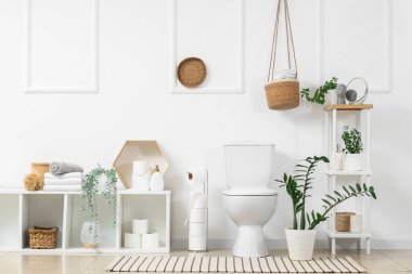 İçinde klozet, raf üniteleri ve bitkiler olan ışık tuvaleti.