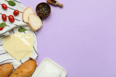 Lezzetli işlenmiş peynir dilimli peçete, leylak arkaplanda ekmek ve domates. Üst görünüm