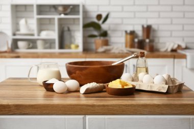 Mutfak tezgahında hamur hazırlamak için un, kase, yumurta, tereyağı ve sütle kepçe