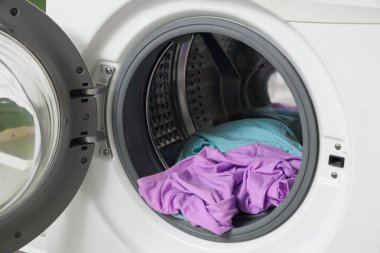 Kirli çamaşırları olan çamaşır makinesini aç, kapat.