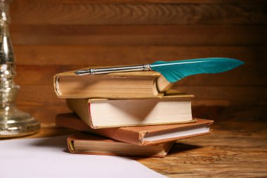 Ahşap zemin üzerinde kalem ve kağıt çarşaflı kitaplar