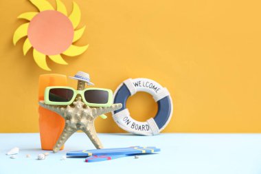 Deniz yıldızı, güneş kremi şişesi ve plaj aksesuarları.