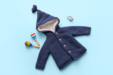 Emzik ve mavi arka planda marakas olan bebek kıyafetleri.