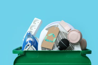 Mavi arkaplanda geri dönüşüm için elektronik atık bulunan çöp kutusu