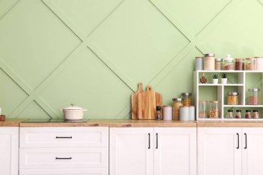 Modern mutfağın içinde elektrikli ocak ve mutfak gereçleri var, yakın plan.