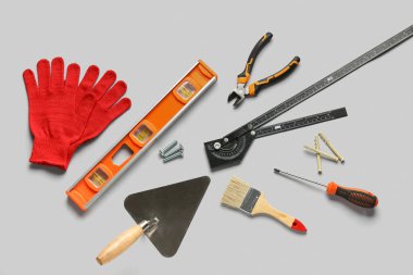 Gri arkaplanda eldivenler ve inşaat araçları