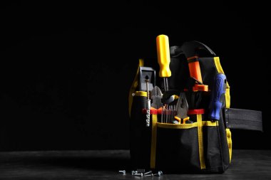 Siyah arkaplanda inşaat araçları olan çanta