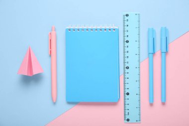 Pembe ve mavi arka planda kağıt uçaklı okul kırtasiyesi.